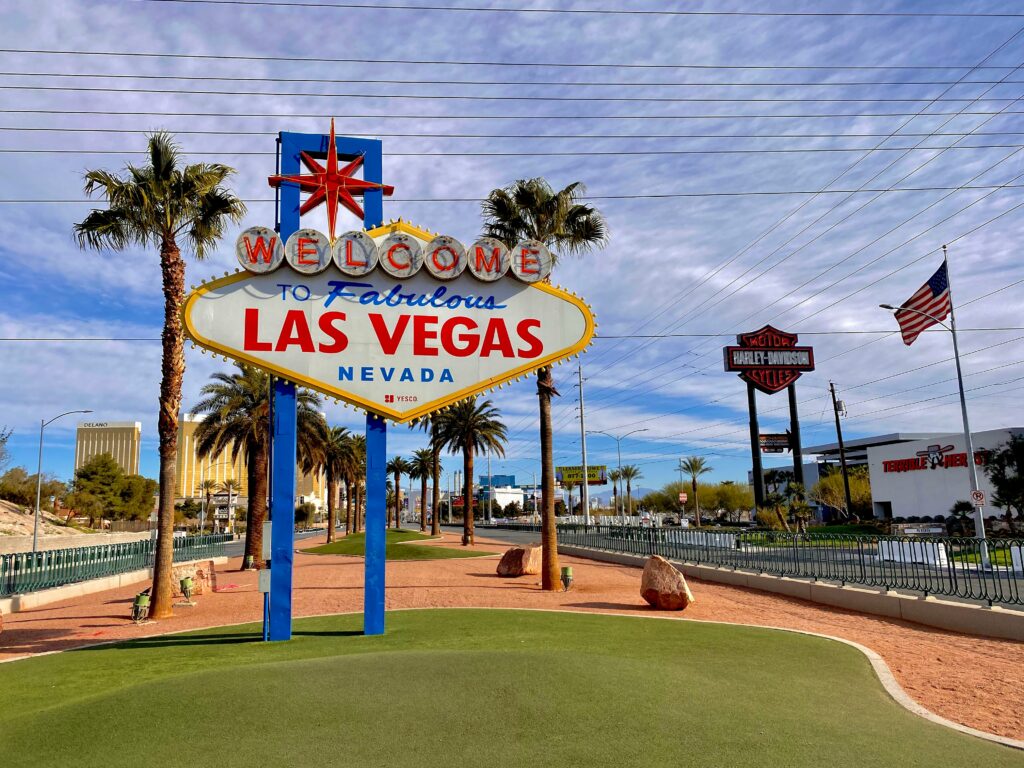 The iconic 'Welcome to Las Vegas' sign, drenched in neon lights against a night sky, epitomizes the city's exuberance.